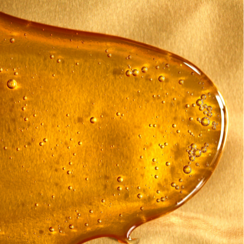 spilled honey on top of a golden surface