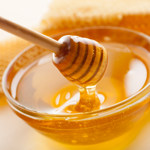 honey drizzler held over a bowl of honey