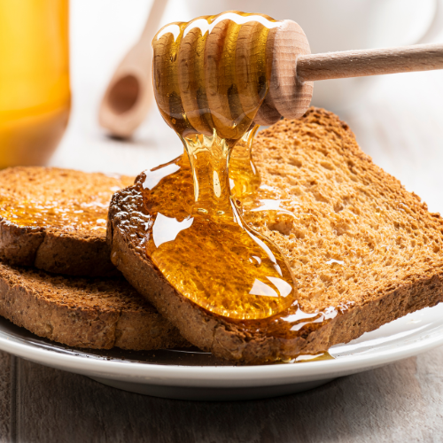 honey being drizzled over a pile of toast